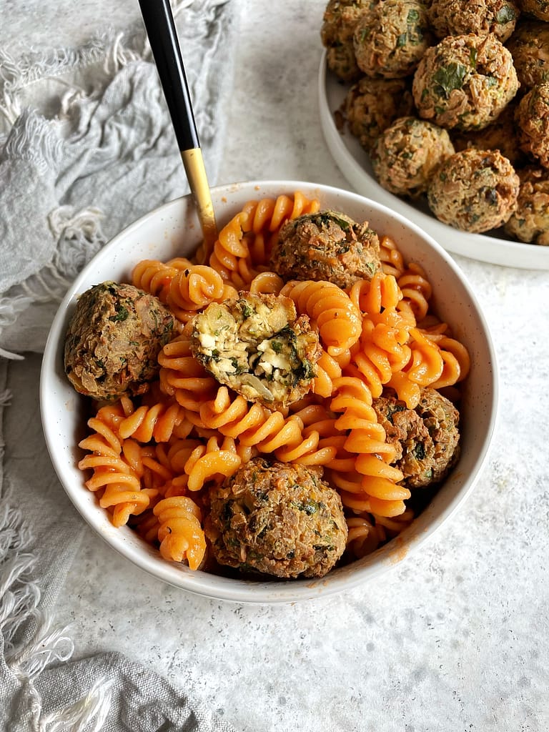 Easy Greek Tofu Meatballs in a bowl of pasta with marinara sauce